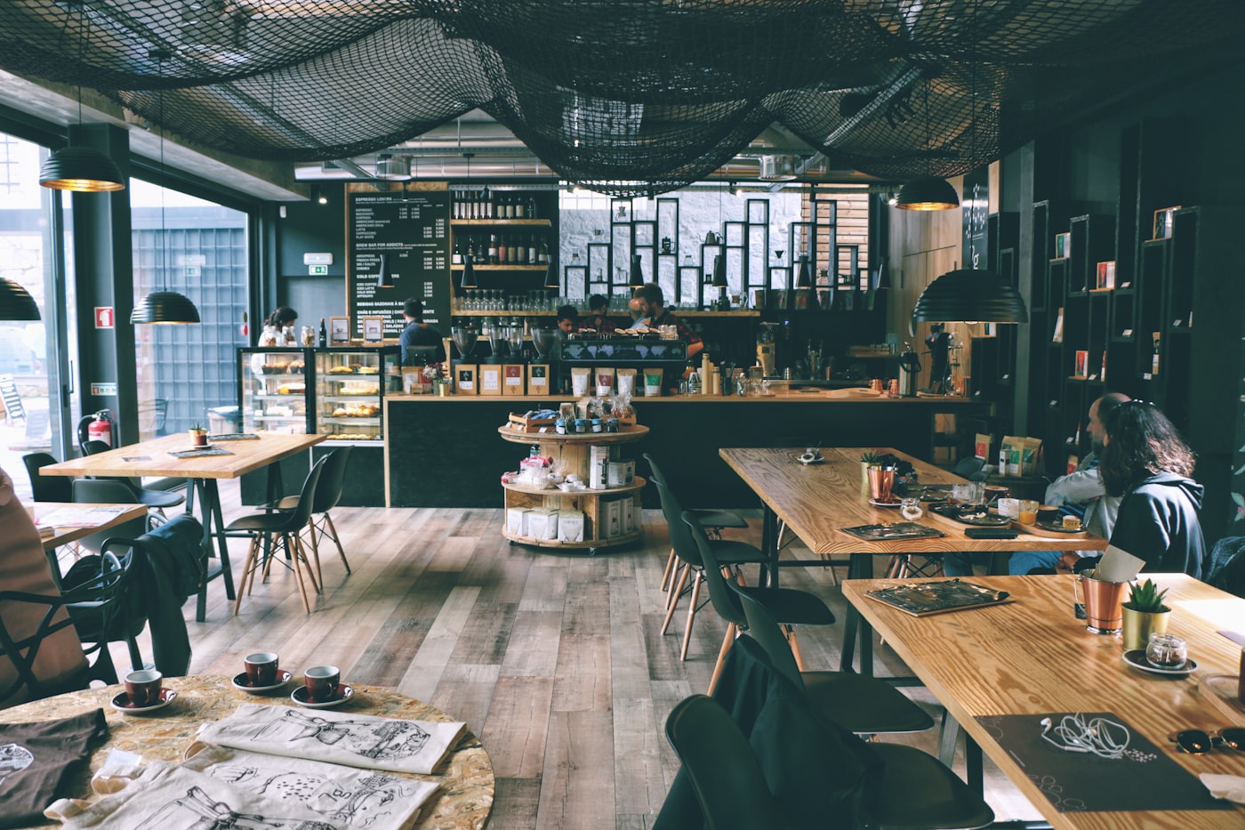 Two people talking over coffee in a dark coffee shop