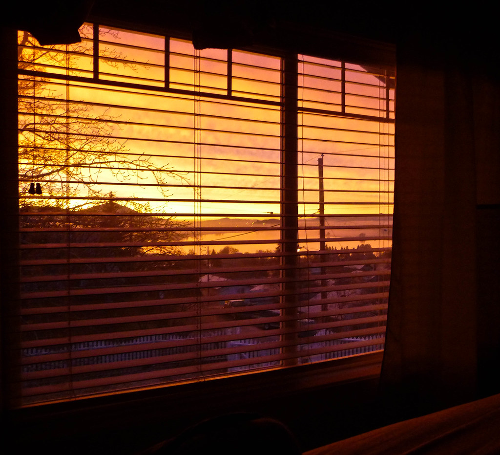 Sunrise streaming through bedroom window blinds