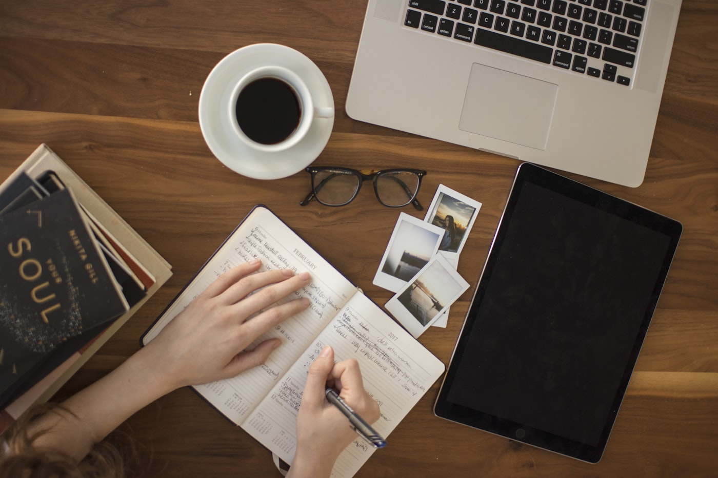 Notebook, laptop and coffee on a wooden desk